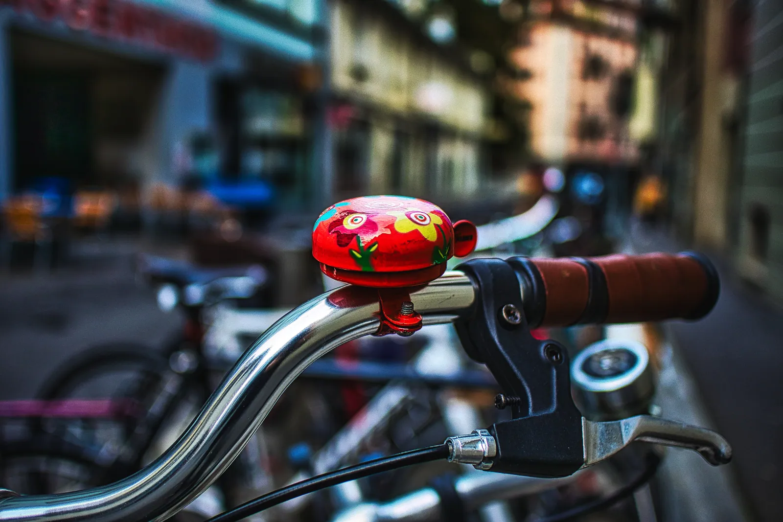 Bicycle bells and mirrors arranged on a workshop bench: a brass classic bell, an electronic bell, a bar-end mirror, and a helmet-mounted mirror