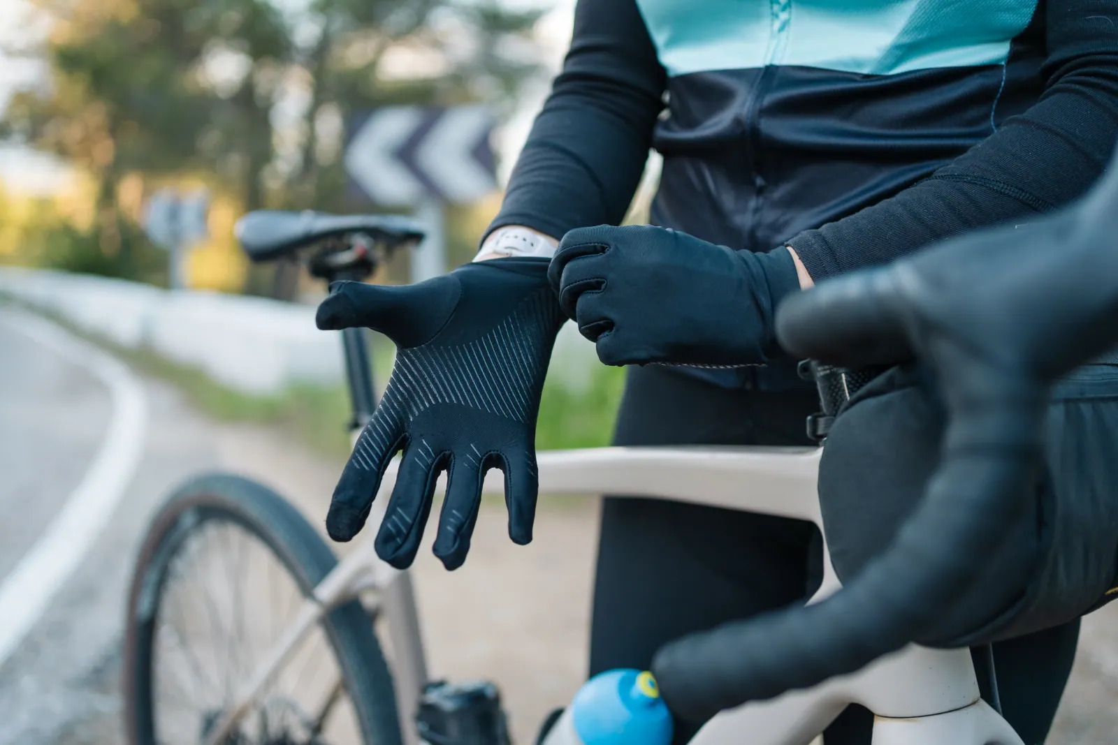 Short-finger road, MTB, winter and downhill armored bike gloves arranged together on a workshop bench, signalling the wholesale range at a glance
